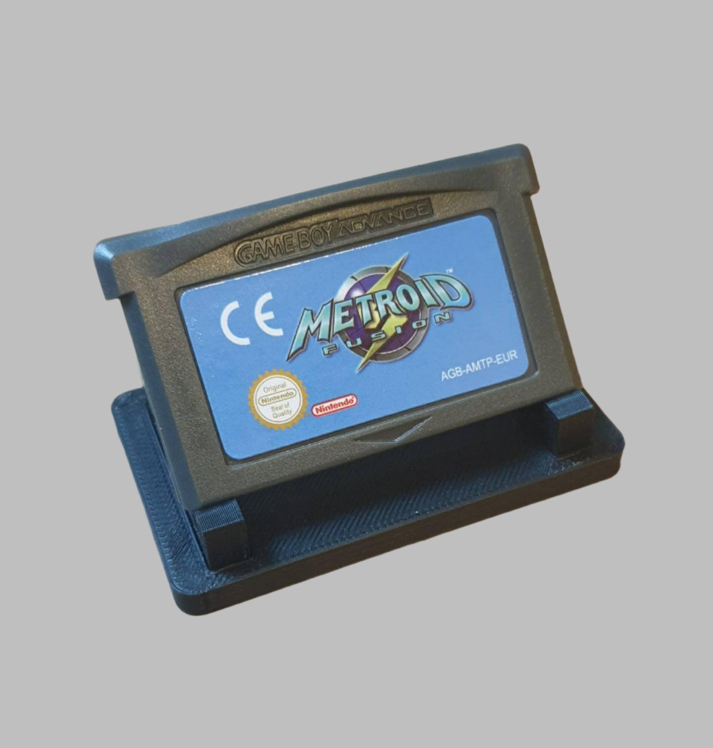 Game Boy Advance game cartridge with 'Metroid' branding on a wooden surface